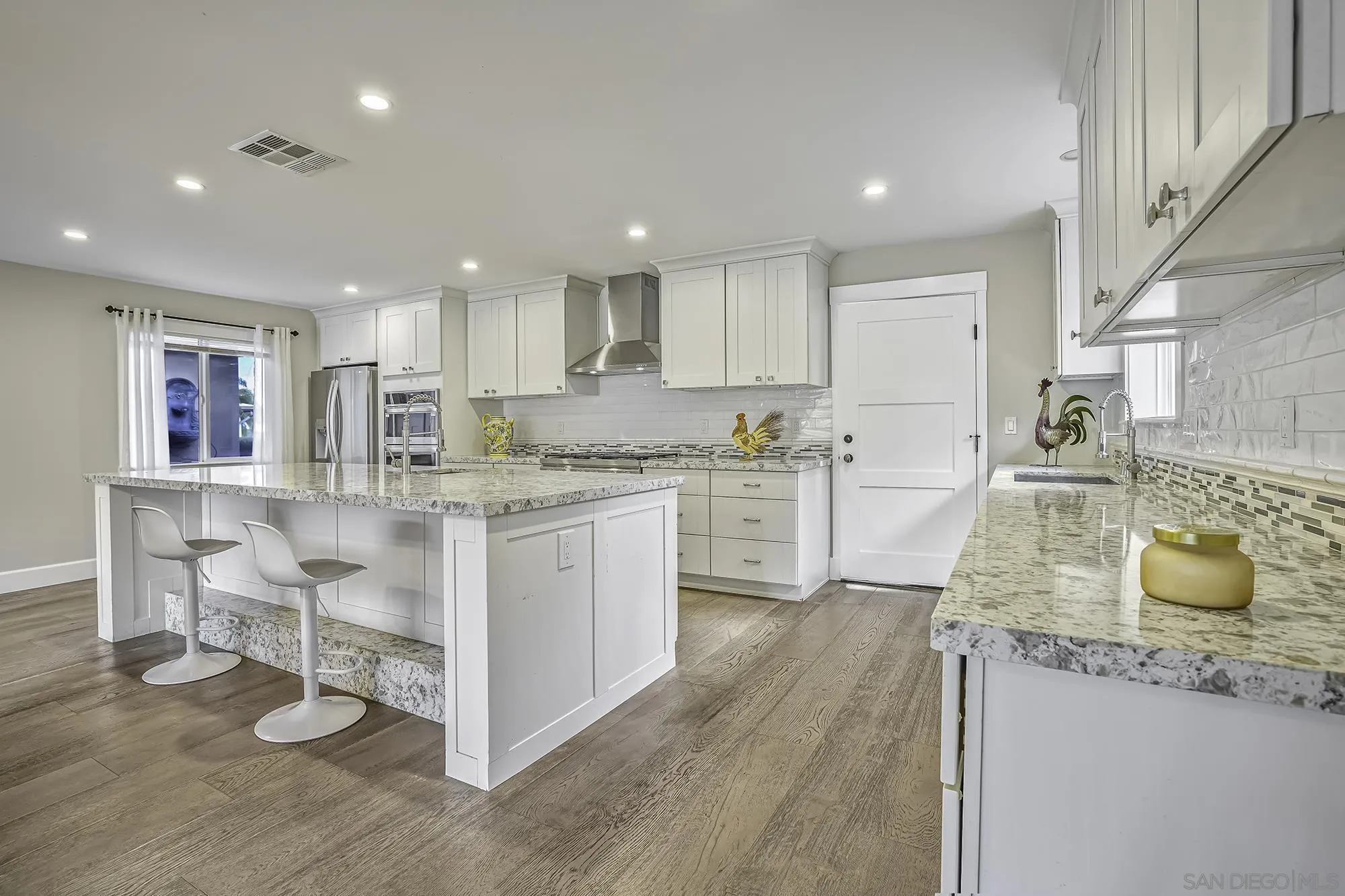 2826 Palomino Circle La Jolla, CA 92037 - Photo 3 of 34 a kitchen with kitchen island granite countertop a sink cabinets and wooden floor