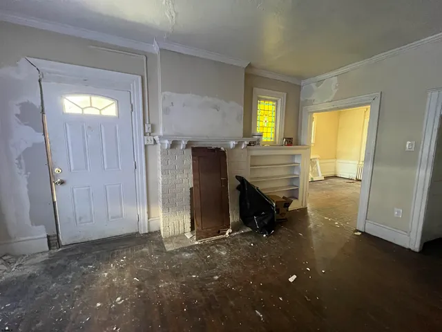 a view of an empty room with a fireplace and a window