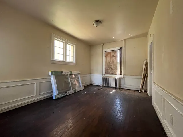 a view of a room with wooden floor and window