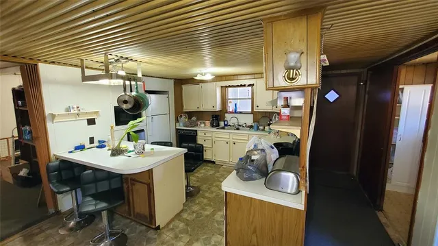 a kitchen with a sink appliances cabinets and furniture