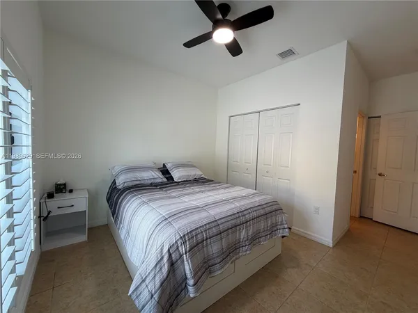 a bedroom with a bed and a flat tv screen on the dresser