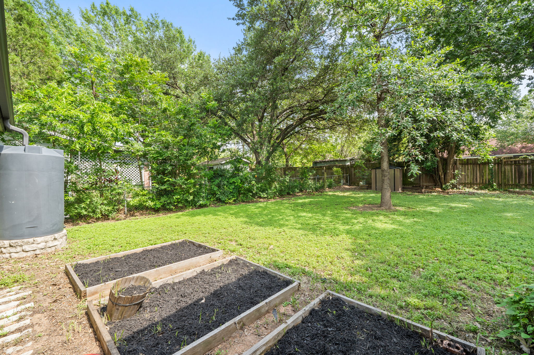 705 Dulwich Street Austin, TX 78748 - Photo 33 of 36 Green yard provides ample space for gardening with raised beds, perfect for cultivating your favorite plants.