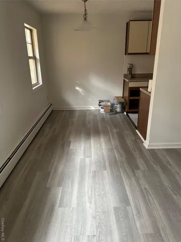 a view of a room with wooden floor and white walls