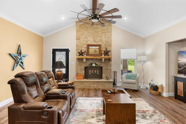 a living room with furniture a fireplace and a chandelier