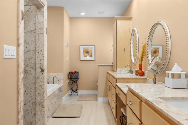 a spacious bathroom with double vanity sink a mirror and a shower