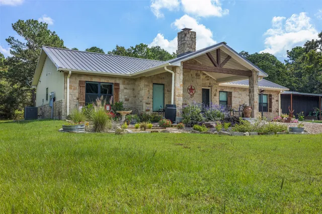 a front view of a house with a garden and plants