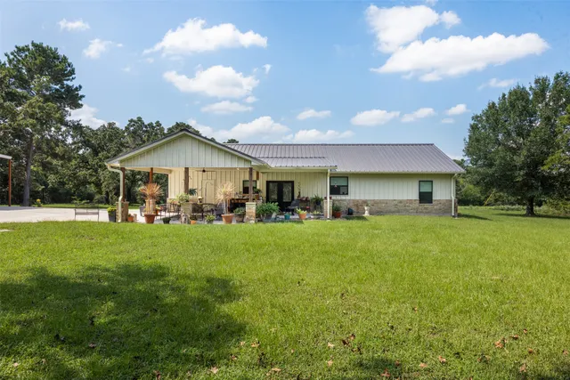 a front view of a house with a garden and trees