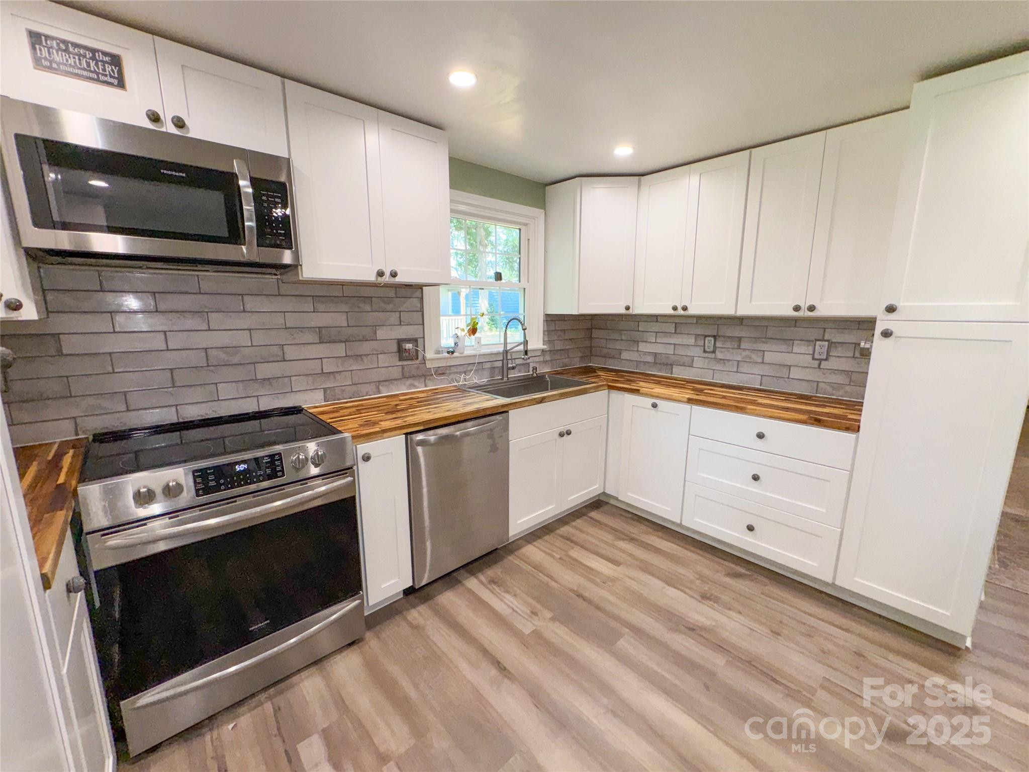 368 Gaddy Farm Road Mount Gilead, NC 27306 - Photo 3 of 25 a kitchen with white cabinets stainless steel appliances and sink