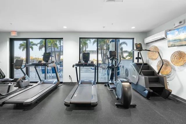a room with gym equipment and large windows