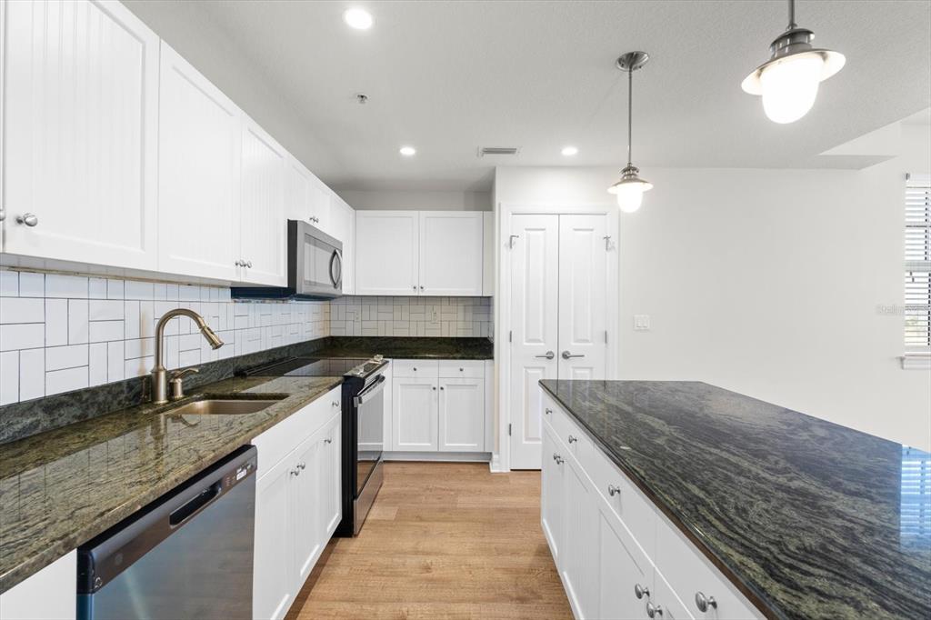 536 Bahia Beach Boulevard, Unit 222B Ruskin, FL 33570 - Photo 5 of 31 a kitchen with granite countertop stainless steel appliances sink stove and cabinets