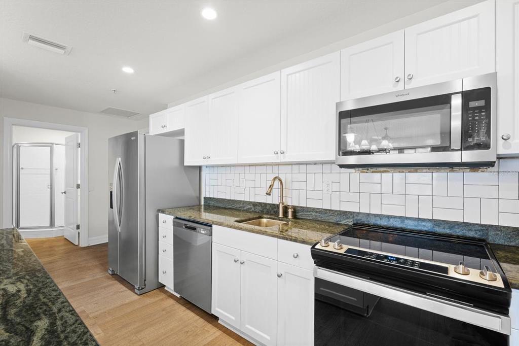 536 Bahia Beach Boulevard, Unit 222B Ruskin, FL 33570 - Photo 6 of 31 a kitchen with stainless steel appliances granite countertop a sink stove and refrigerator
