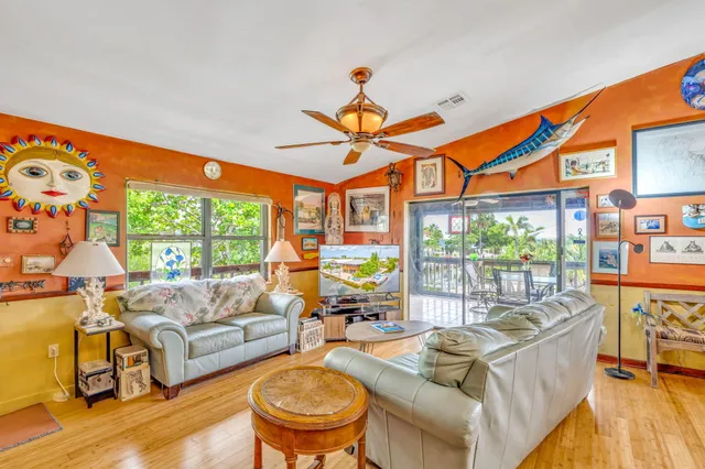 a living room with furniture a floor to ceiling window and a flat screen tv