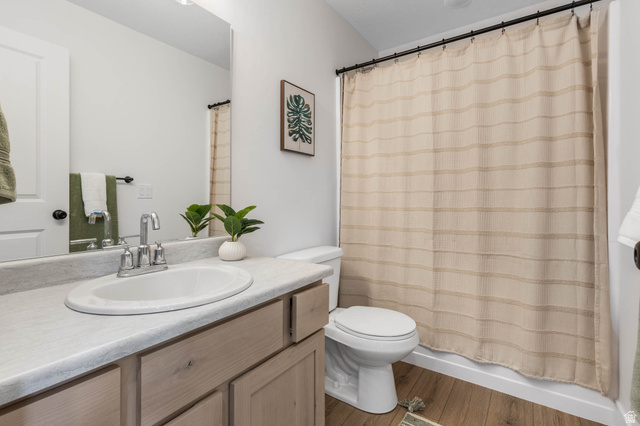 636 West Caroles Way, Unit 7 Tooele, UT 84074 - Photo 19 of 31 Bathroom featuring a light wood-finish vanity with an undermount sink, a white countertop, and wood-finish flooring