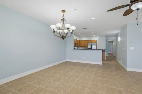 an empty room with windows and ceiling fan