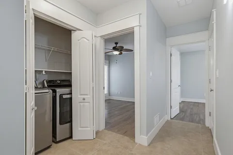 an empty room with windows and fan