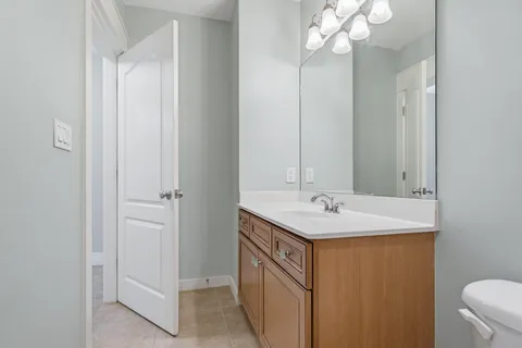 a bathroom with a granite countertop sink a toilet and shower