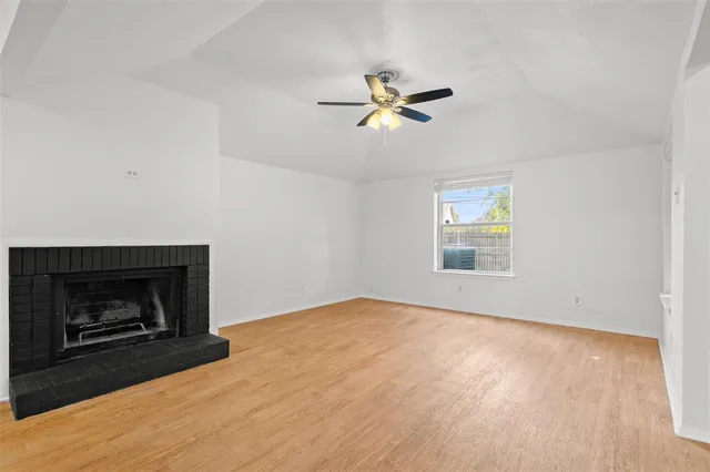 an empty room with windows and fireplace