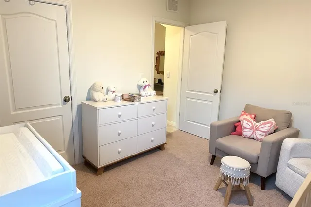 a living room with furniture and a baby crib
