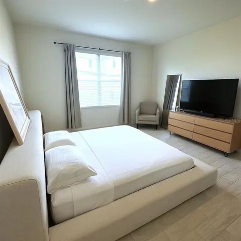 a bedroom with a bed and a flat screen tv