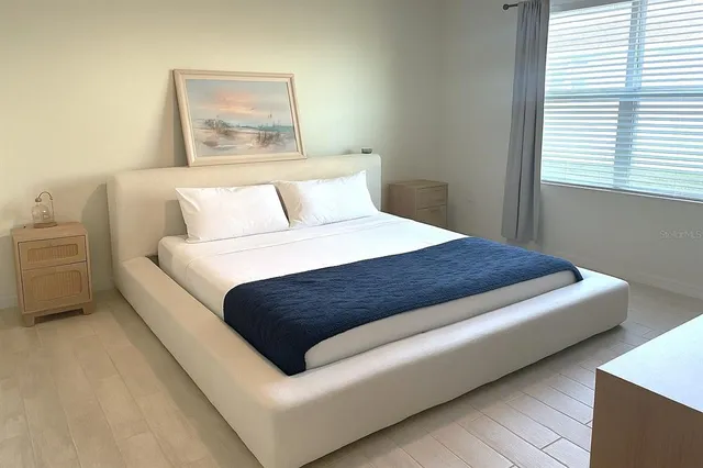 a large bed sitting in a bedroom next to a window