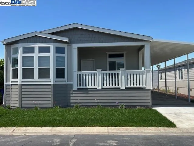 a view of a house with a small yard and wooden fence