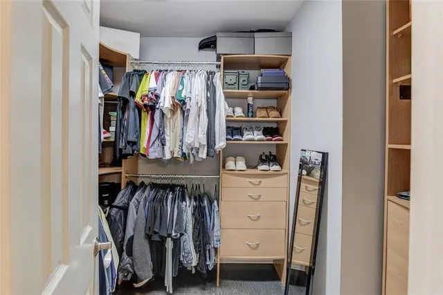 a view of walk in closet with clothes and shoes