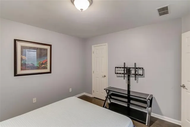 a bedroom with a bed and a painting on the wall