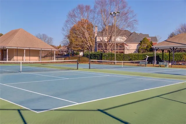 a view of a tennis ground with large trees