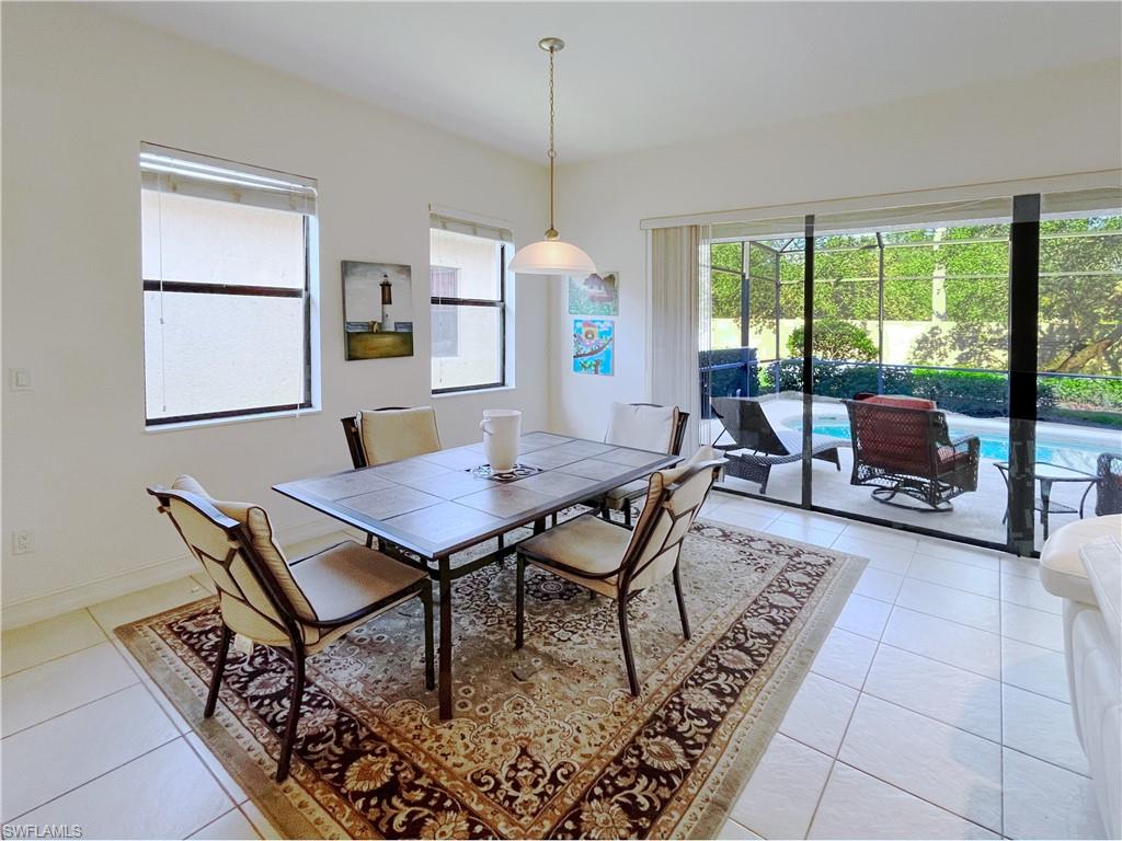 1366 Serrano Circle Naples, FL 34105 - Photo 12 of 30 a living room with furniture a table and a floor to ceiling window