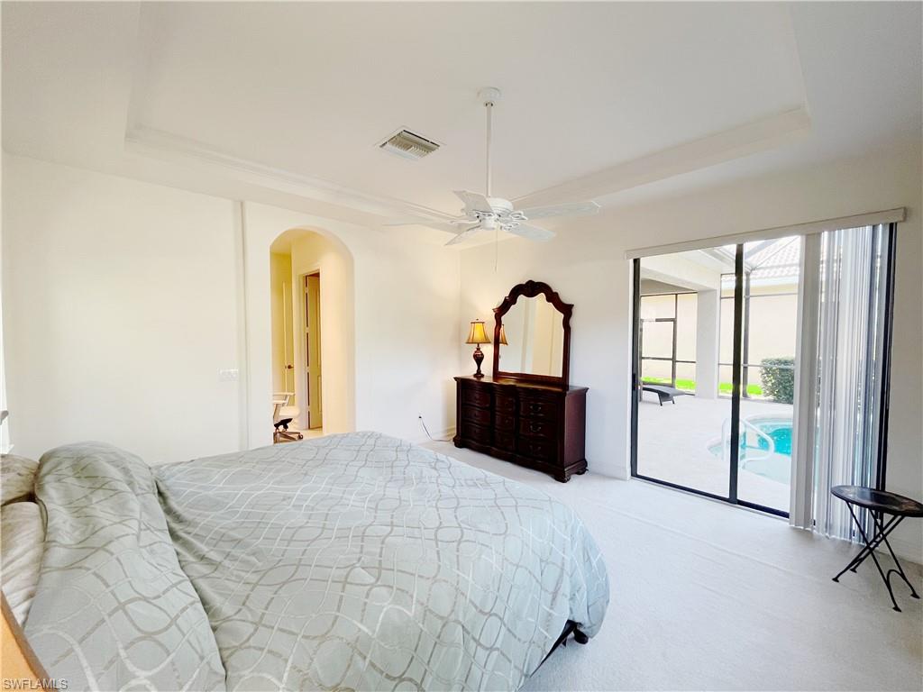 1366 Serrano Circle Naples, FL 34105 - Photo 17 of 30 a large bedroom with a bed and large mirror next to a window