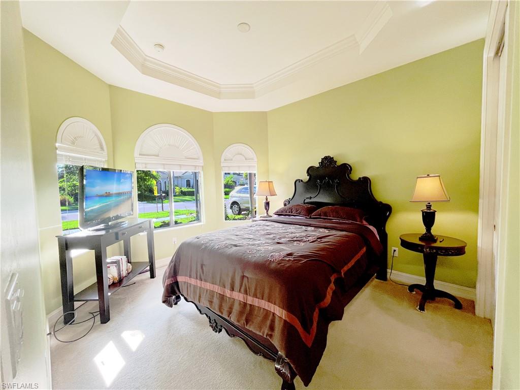 1366 Serrano Circle Naples, FL 34105 - Photo 18 of 30 a bedroom with a bed and a table lamp