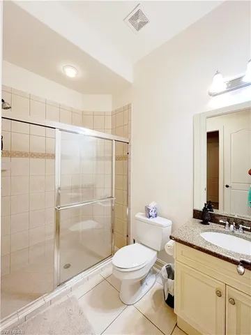 a bathroom with a granite countertop sink a toilet and shower