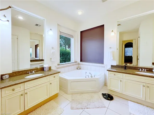 a spacious bathroom with a tub sink and mirror