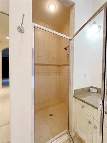 a bathroom with a granite countertop shower and a sink