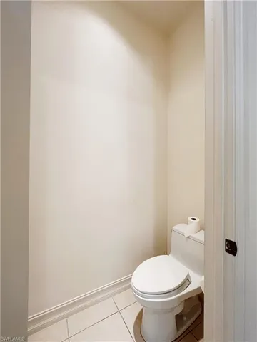 a white toilet sitting next to a white wall