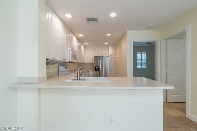 a large kitchen with kitchen island a sink stainless steel appliances and cabinets