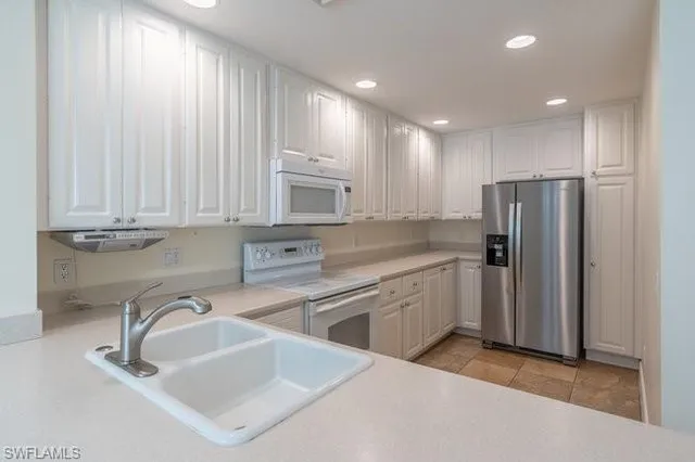 a kitchen with white cabinets and stainless steel appliances