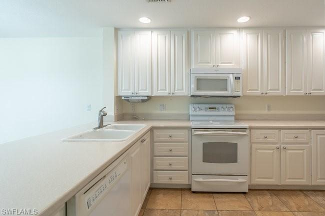 8108 Josefa Way Naples, FL 34114 - Photo 15 of 40 a kitchen with granite countertop white cabinets white stainless steel appliances with a sink and dishwasher
