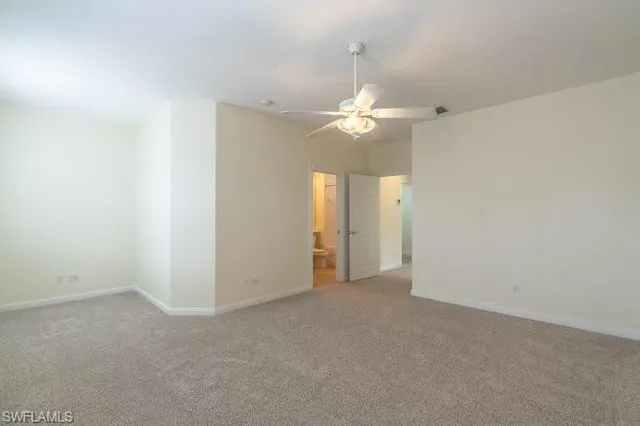 an empty room with a ceiling fan and a bathroom