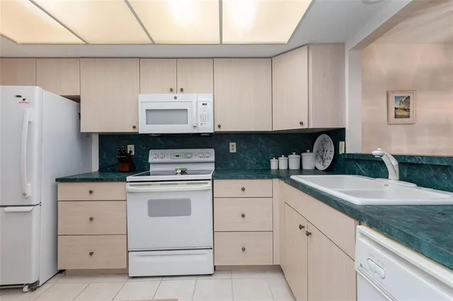 a kitchen with granite countertop white cabinets and stainless steel appliances