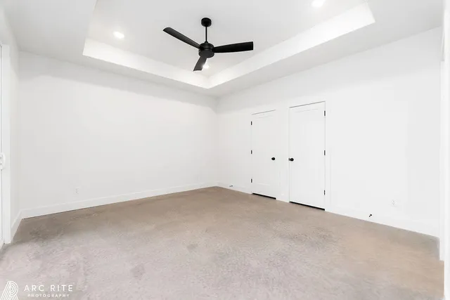 an empty room with a ceiling fan and window