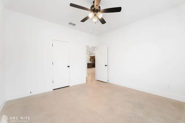 an empty room with chandelier fan