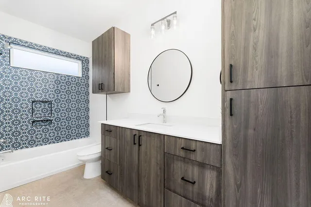 a bathroom with a sink a toilet and shower