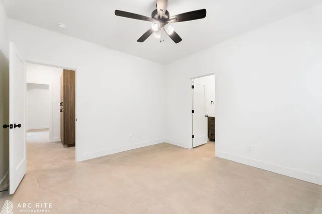an empty room with closet and a chandelier fan