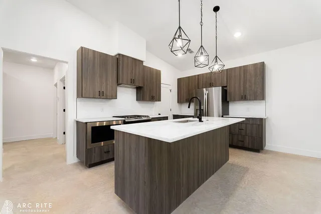 a kitchen with kitchen island granite countertop a sink and a stove