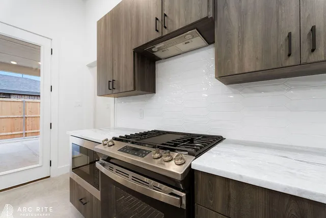 a kitchen with granite countertop a stove and a microwave