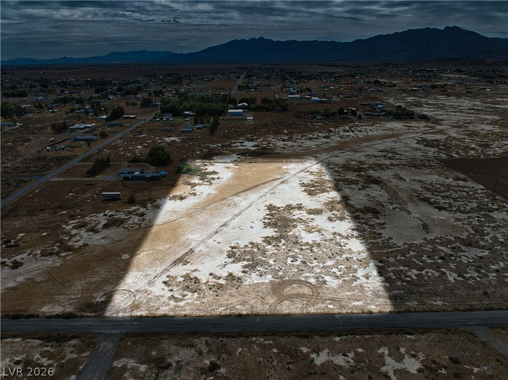 Aerial view of sparsely populated area with a mountainous background and nearby suburban area
