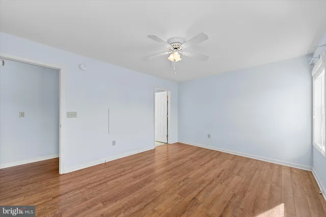 a view of empty room with wooden floor