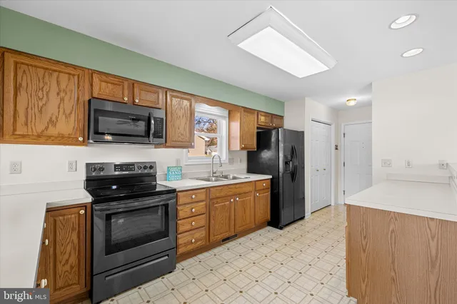 a kitchen with stainless steel appliances granite countertop a refrigerator stove top oven microwave and refrigerator