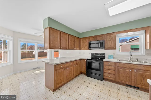 a kitchen with stainless steel appliances granite countertop a stove top oven a sink dishwasher and a refrigerator